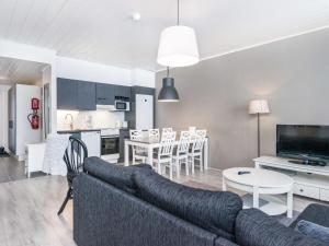 ein Wohnzimmer und eine Küche mit einer Couch und einem Tisch in der Unterkunft Holiday Home Skivillas paljakka 5- - 3mh by Interhome in Kotila