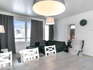een woonkamer met een bank en een tafel en stoelen bij Holiday Home Skivillas paljakka 5- - 3mh by Interhome in Kotila