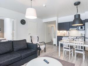 ein Wohnzimmer und eine Küche mit einer Couch und einem Tisch in der Unterkunft Holiday Home Skivillas paljakka 5- - 3mh by Interhome in Kotila