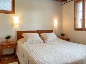 ein Schlafzimmer mit einem weißen Bett und zwei Nachttischen in der Unterkunft Holiday Home Tahkon klubitie 2 a by Interhome in Tahkovuori