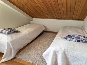 - 2 lits dans une chambre dotée d'un plafond en bois dans l'établissement Holiday Home Tahkon klubitie 2 a by Interhome, à Tahkovuori