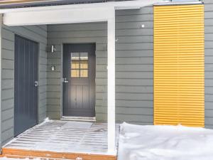 eine Eingangstür eines Hauses mit einer gelben und grauen Tür in der Unterkunft Holiday Home Hallan karhu c- paritalo by Interhome in Hyrynsalmi