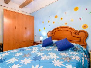 um quarto com uma cama com lençóis azuis e flores na parede em Holiday Home Hostalas by Interhome em Rosell