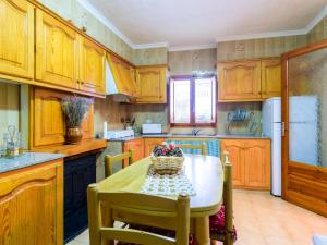 uma cozinha com armários de madeira e uma mesa com um cesto de flores em Holiday Home Hostalas by Interhome em Rosell