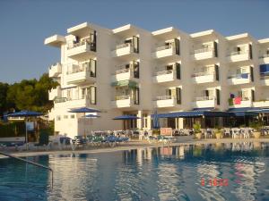a hotel with a swimming pool in front of a building at Apartamentos Vistamar in Santo Tomás