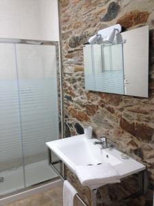 a bathroom with a sink and a shower and a mirror at Recanto na Planicie in Monsaraz