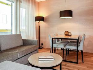 a living room with a couch and a table at Holiday Home Levin kunkku b5 by Interhome in Levi +8 photos