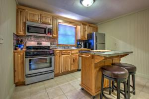 una cocina con armarios de madera y electrodomésticos de acero inoxidable en Linville Falls Lodge & Cottages, en Linville Falls