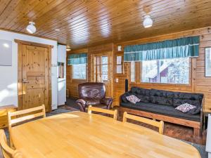 uma sala de estar com uma mesa e um sofá em Holiday Home Kulma-alpit a paritalon yläk by Interhome em Hyrynsalmi