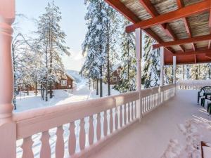 uma vista de Inverno a partir do alpendre de uma casa com árvores cobertas de neve em Holiday Home Kulma-alpit a paritalon yläk by Interhome em Hyrynsalmi