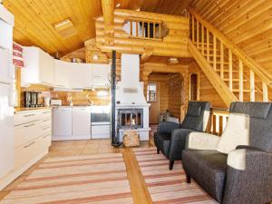 uma cozinha e sala de estar com lareira num chalé de madeira em Holiday Home Alppimaja b paritalo by Interhome em Hyrynsalmi