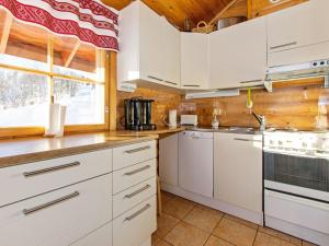 eine Küche mit weißen Schränken und einem Fenster in der Unterkunft Holiday Home Alppimaja b paritalo by Interhome in Hyrynsalmi