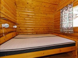 eine Holzhütte mit einem Bett in einem Zimmer in der Unterkunft Holiday Home Alppimaja b paritalo by Interhome in Hyrynsalmi + 7 Fotos