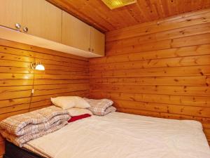 a small room with a bed in a wooden wall at Holiday Home Lohiukko by Interhome in Kotila