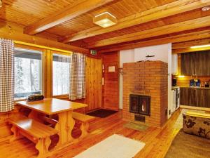 a living room with a table and a fireplace at Holiday Home Lohiukko by Interhome in Kotila