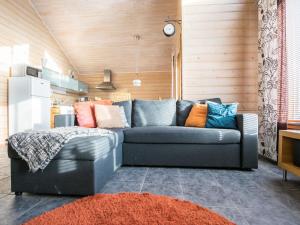 a living room with a blue couch with colorful pillows at Holiday Home Rinteenkotka cottage by Interhome in Hyrynsalmi