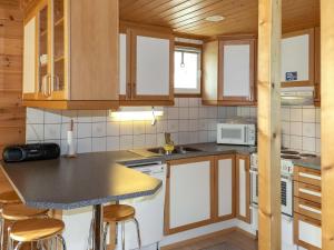 een keuken met houten kasten en een aanrecht bij Holiday Home Miilumaja a1 by Interhome in Kotila