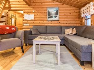 a living room with a couch and a table at Holiday Home Kultapaljakka 4 by Interhome in Kotila