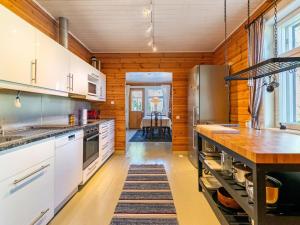 uma cozinha com armários brancos e uma parede de madeira em Holiday Home Villa nytorp by Interhome em Stormälö