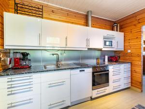 uma cozinha com armários brancos e um lavatório em Holiday Home Villa nytorp by Interhome em Stormälö
