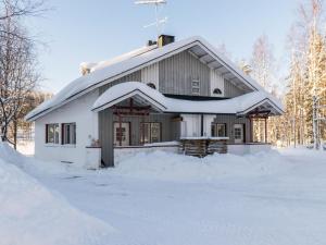 dom pokryty śniegiem z kupą śniegu w obiekcie Holiday Home Hallantytär b4 paritalo by Interhome w mieście Hyrynsalmi