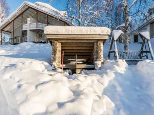 a fireplace covered in snow in front of a house at Holiday Home Hallantytär b4 paritalo by Interhome in Hyrynsalmi