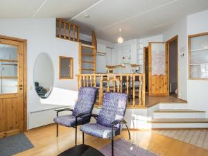 sala de estar con 2 sillas y escalera en Holiday Home Ukonpuoti b13 kerrostalo by Interhome, en Hyrynsalmi