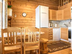 a kitchen with a table and chairs and a refrigerator at Holiday Home Ukkohovi 3 paritalo by Interhome in Hyrynsalmi