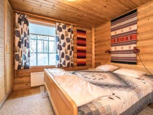 a bedroom with a bed in a log cabin at Holiday Home Ukkohovi 3 paritalo by Interhome in Hyrynsalmi