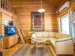 a living room with a couch and a tv at Holiday Home Ukkohovi 3 paritalo by Interhome in Hyrynsalmi