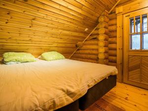 ein Schlafzimmer mit einem Bett in einem Blockhaus in der Unterkunft Holiday Home Metsätähti by Interhome in Kotila