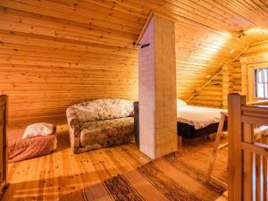 um quarto com uma cama e um sofá numa cabana de madeira em Holiday Home Metsätähti by Interhome em Kotila