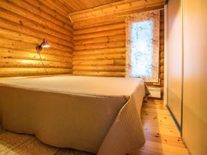 ein Schlafzimmer mit einem Bett in einem Holzzimmer in der Unterkunft Holiday Home Metsätähti by Interhome in Kotila