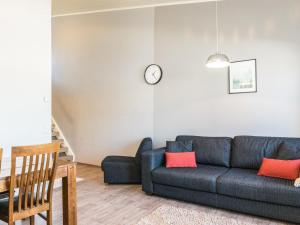 uma sala de estar com um sofá azul e um relógio na parede em Holiday Home Skivillas 61 ukkohalla - b4 by Interhome em Hyrynsalmi
