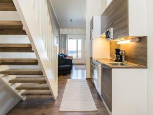 una cocina con una escalera que conduce a una sala de estar. en Holiday Home Skivillas 61 ukkohalla - b4 by Interhome en Hyrynsalmi