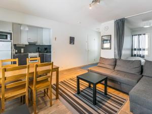 a living room and kitchen with a couch and a table at Holiday Home Kotipaljakka a2 by Interhome in Kotila