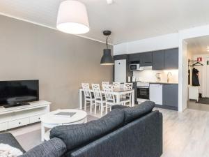 ein Wohnzimmer mit Couch und Tisch und eine Küche in der Unterkunft Holiday Home Skivillas paljakka 4- - 2 bedrooms by Interhome in Kotila