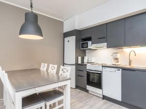 eine Küche mit Tisch und Stühlen in einem Zimmer in der Unterkunft Holiday Home Skivillas paljakka 4- - 2 bedrooms by Interhome in Kotila + 8 Fotos