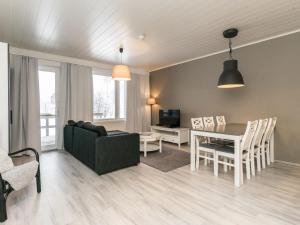 ein Wohnzimmer mit einem Sofa und einem Esstisch in der Unterkunft Holiday Home Skivillas paljakka 4- - 2 bedrooms by Interhome in Kotila