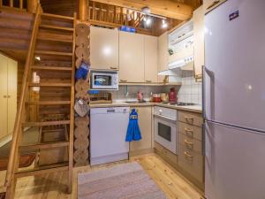 a kitchen with a white refrigerator and a ladder at Holiday Home Kultapaljakka 3 by Interhome in Kotila