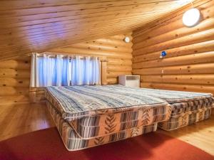a bedroom with a bed in a log cabin at Holiday Home Kultapaljakka 3 by Interhome in Kotila