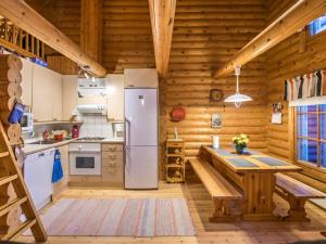 a kitchen with a refrigerator and a table at Holiday Home Kultapaljakka 3 by Interhome in Kotila