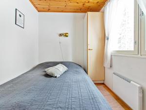 a bedroom with a bed with a pillow on it at Holiday Home Lomarivi c4 by Interhome in Kotila