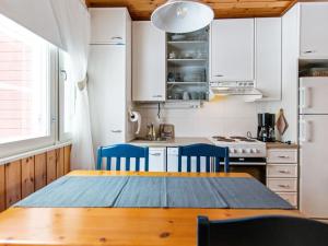 uma cozinha com uma mesa de madeira e cadeiras azuis em Holiday Home Lomarivi c4 by Interhome em Kotila