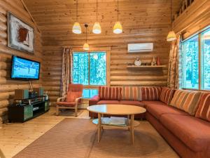 sala de estar con sofá y mesa en Holiday Home Sateenkaari cottage by Interhome en Hyrynsalmi