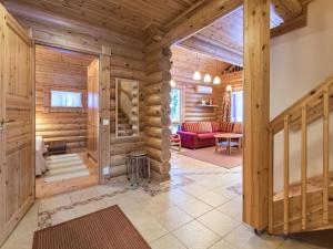 Cabaña de madera con sala de estar con sofá rojo en Holiday Home Sateenkaari cottage by Interhome en Hyrynsalmi