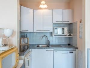 une cuisine avec des armoires blanches et un évier dans l'établissement Apartment Résidence Les Dunes by Interhome, à Quiberon
