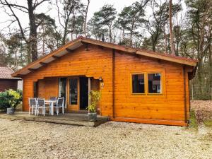 a small wooden cabin with a table and chairs at Holiday Home De Brenkberg in Schinveld