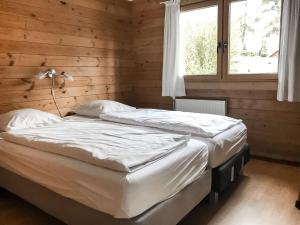two beds in a wooden room with a window at Holiday Home De Brenkberg in Schinveld