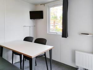 einen Tisch und Stühle in einem Zimmer mit Fenster in der Unterkunft Holiday Home De Brenkberg-1 in Schinveld